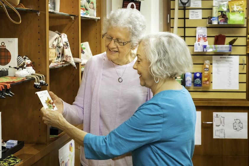 Two senior ladies looking at merchandise in a store